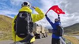 网友骑行路遇军车，激动地举起国旗挥舞敬礼，路过的每辆军车都鸣笛回应
