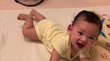 小宝宝一脸呆萌的练趴着，突然露出开心的笑容把妈妈都逗笑了！