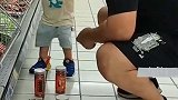 男子在超市教育一岁半的儿子，将放在地上的物品放回原位