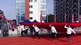高校运动会开幕式，四名教师手举国旗穿过方阵