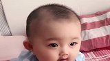 小宝宝坐在床上撒娇，治愈系的微笑太萌了，好想亲她一口