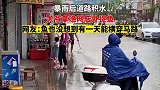 暴雨后道路积水，大爷拿渔网店外捉鱼