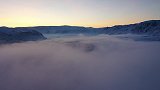 新疆布尔津河岸现大范围雾凇云海 万道金光穿过美若仙境