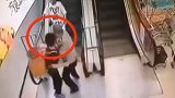 惊险！扶梯上娃儿翻出背篓 保安大叔箭步上前抱住