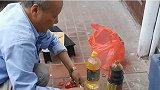 大爷蹲在路上，用小锅炒菜