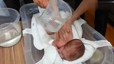 刚出生小婴儿第一次洗澡，小家伙趴着不哭也不闹，太讨人喜欢了