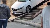 轿车下楼慢悠悠，路人见状拿来木板垫着