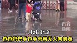 小宝自己推车挡雨紧跟爸妈  这届的父母太有才了！