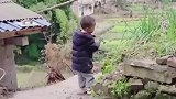 男孩无聊自己玩，拿着铁锤钉石头玩
