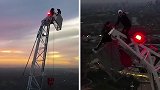 找刺激！英国两名冒险者爬上170米高塔吊顶端看日出