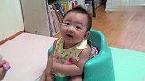 坐在自己的小椅子上，笑得好灿烂啊