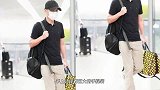 文章戴帽穿黑T休闲随性肩扛又手提低调埋头赶路