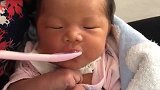 奶奶用勺子喂小宝宝喝水，宝宝把嘴巴撅得高高的，这是有多渴啊