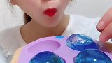 蓝色的空心冰球，小姐姐一口一个吃的真带劲，我也好想吃一个