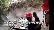 男子发现围墙异样提醒路人，话音刚落围墙倒塌，女子带娃躲过一劫