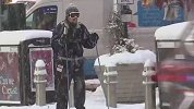 美国东北部遭暴风雪袭击大部分地铁飞机停运 男子公路上滑雪前行