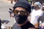 帽子眼镜口罩全副武装 拉塞尔街头参加游行活动拿手机直播