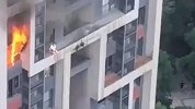 家中起火熊熊火苗从窗户蹿出 女子抱宠物坐楼外平台等待救援