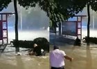 暴雨袭城：女子马路摔倒后连人带车被冲走 三名男子扑入水中救人