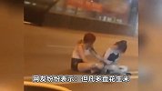 危险！下班高峰期2女子盘坐马路中央，车来车往依旧淡定玩手机