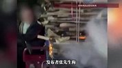 大爷骑三轮车抽烟，后斗纸壳起火，路人骑电动车追赶提醒