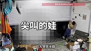 男孩衣服不慎被卷帘门勾住，哭喊求助，爸爸拿出手机拍照.“以后就会长记性了”