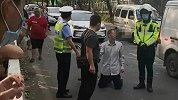 50岁男子未佩戴头盔被罚当街下跪 警方：涉嫌非法营运