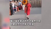 考场外神仙家长让人一秒破防：爸爸穿旗袍拿向日葵，有家庭团举牌应援