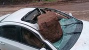 雨后山上滚落巨石砸中行驶中轿车 直击路人出手搬石救人