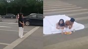 山东一情侣半裸裹床单睡斑马线拍婚纱照 身边来往车辆不断