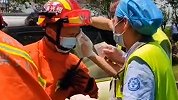  消防员抢救车祸司机汗水不止流入眼 离场时，护士上前为他擦汗