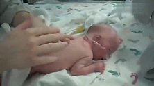 医生给新生儿做抚触按摩，宝宝乖乖的趴着，非常享受