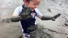 小男孩跑到烂泥坑里玩，妈妈竟然还在一旁笑，这娃是不打算要了吗