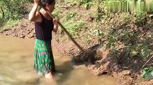 乡间姑娘河边抓鱼，不料水里泥土湿滑，一下滑到到鱼坑，当场乐坏