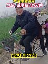 安徽阜阳：奶奶坐爷爷自行车后座，怀里捧着鲜花