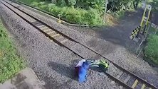 印尼母子三人骑摩托过铁道时被卡 弃车逃走险些被撞