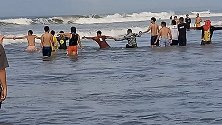 菲律宾海滩游客组成人链从波涛汹涌的大海中救出溺水男子