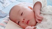 小宝宝躺在床上动来动去，一会奶从鼻子里流下来了，看着好心疼！