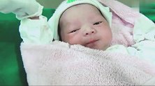 新生儿宝宝用包被包裹着，接下来宝宝的动作，把老阿姨的心萌化了
