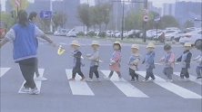 浙江嘉兴：幼儿园老师拉绳子保护萌娃过马路 网友：萌化了
