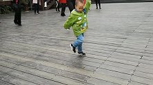 公园里两岁多的小孩和大人一起跳起了广场舞