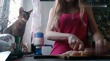 猫咪看女主人切肉馋了，不停的拽主人胳膊暗示自己要吃肉