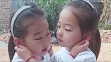 双胞胎姐妹打架，各自揪着对方的耳朵，这俩宝的表情真到位啊