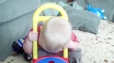 把头套进玩具里的宝宝，呆呆的趴在玩具上，真搞笑！
