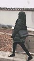 小姐姐黑色卷发披散在腰间，内搭白色T恤和黑色短裙，好看又时尚