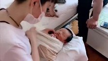 孕婴师给小宝宝穿衣服，接下来宝宝的表情好萌，真可爱！