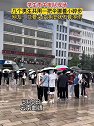 云南曲靖：学生雨中排队，几个男生共用一把伞挪着小碎步
