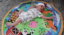 刚出生一周的新生宝宝乖乖的躺在游戏垫上好可爱啊