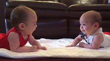 双胞胎趴在一起玩，彼此看一眼就开始笑，笑的口水都流出来了