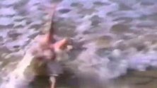 孩子们在沙滩上肆意玩耍，一个孩子看见波浪过来，赶紧向后走！